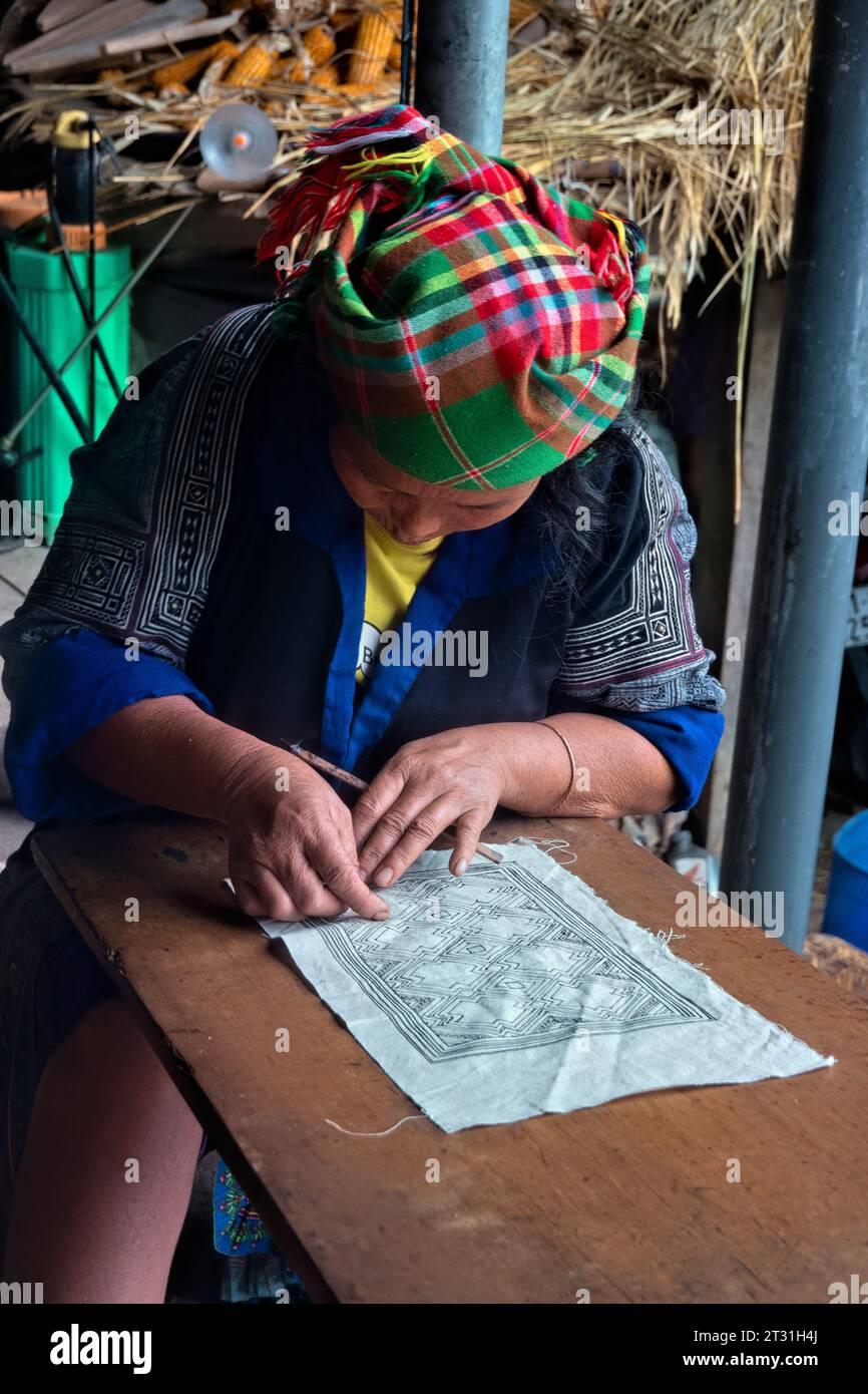 Una donna Flower Hmong disegna un modello per il suo ricamo tradizionale, Mu Cang Chai, Yen Bai, Vietnam Foto Stock