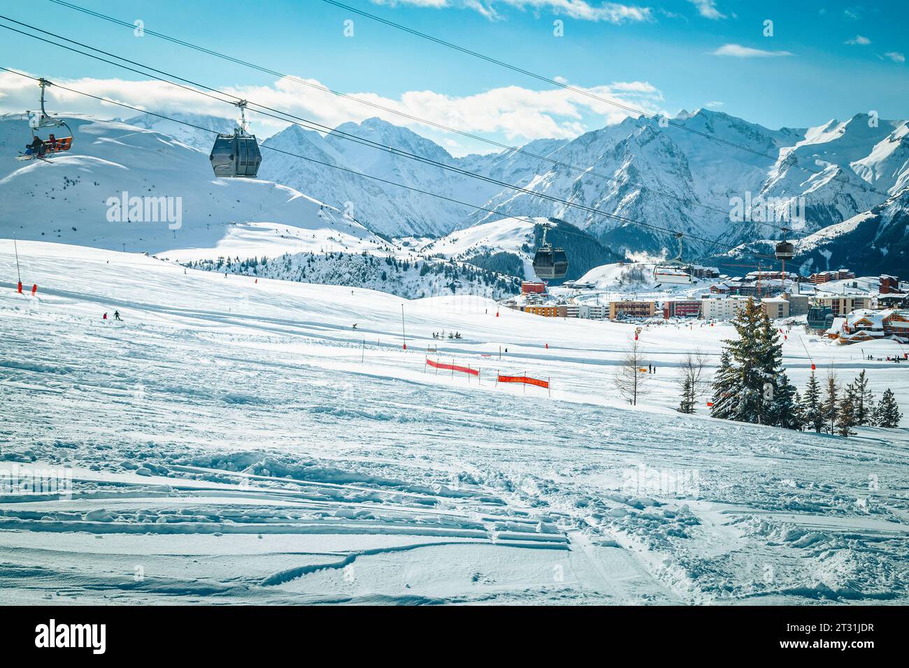 Fantastico campo da sci con piste da sci sulle fresche e profonde colline innevate. Stazione sciistica invernale con sciatori e funivie, Alpe d Huez, Francia, Europa Foto Stock