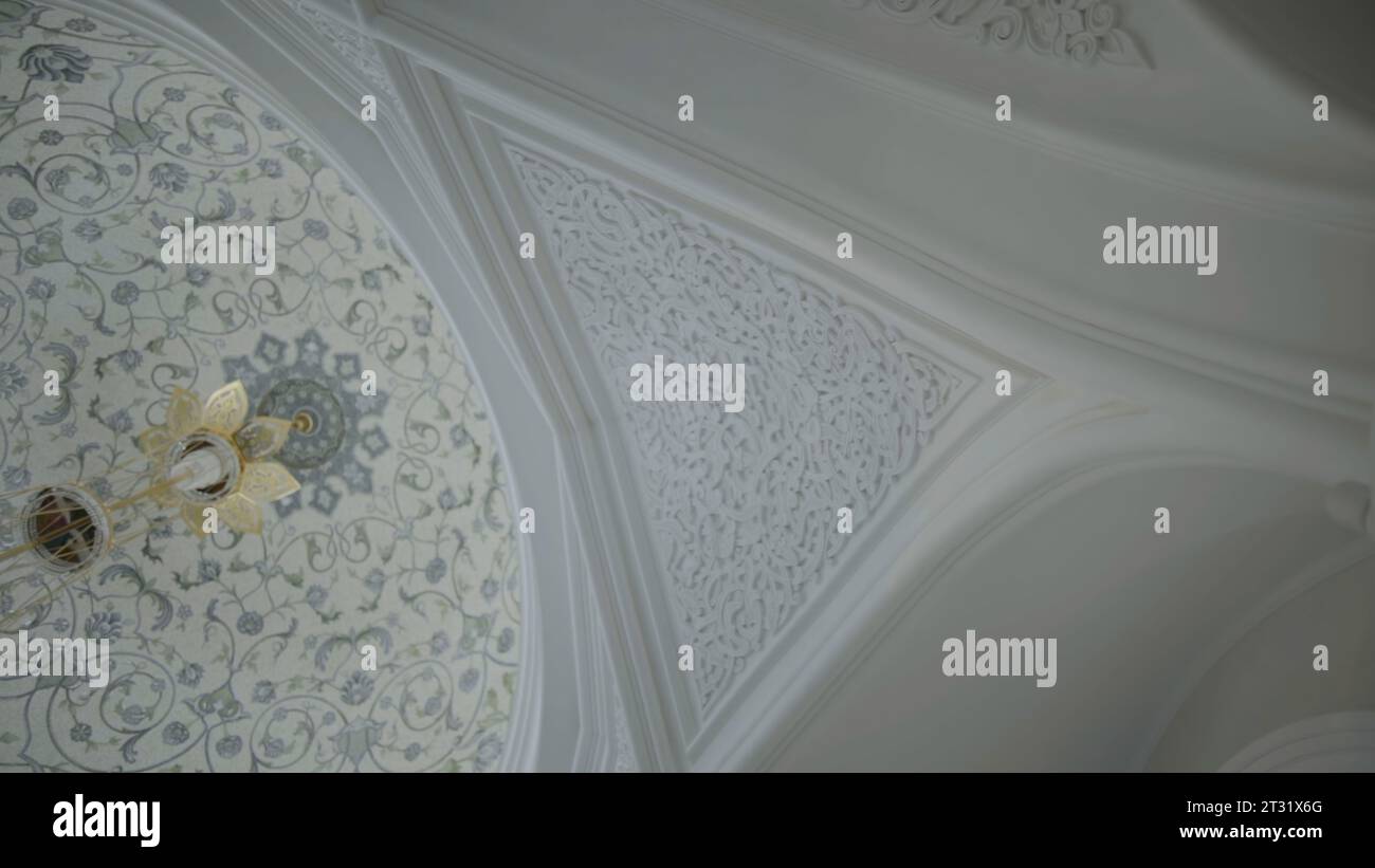 Vista dal basso angolo del soffitto bianco con splendidi ornamenti. Scena. Decorazioni intagliate e motivi floreali. Foto Stock