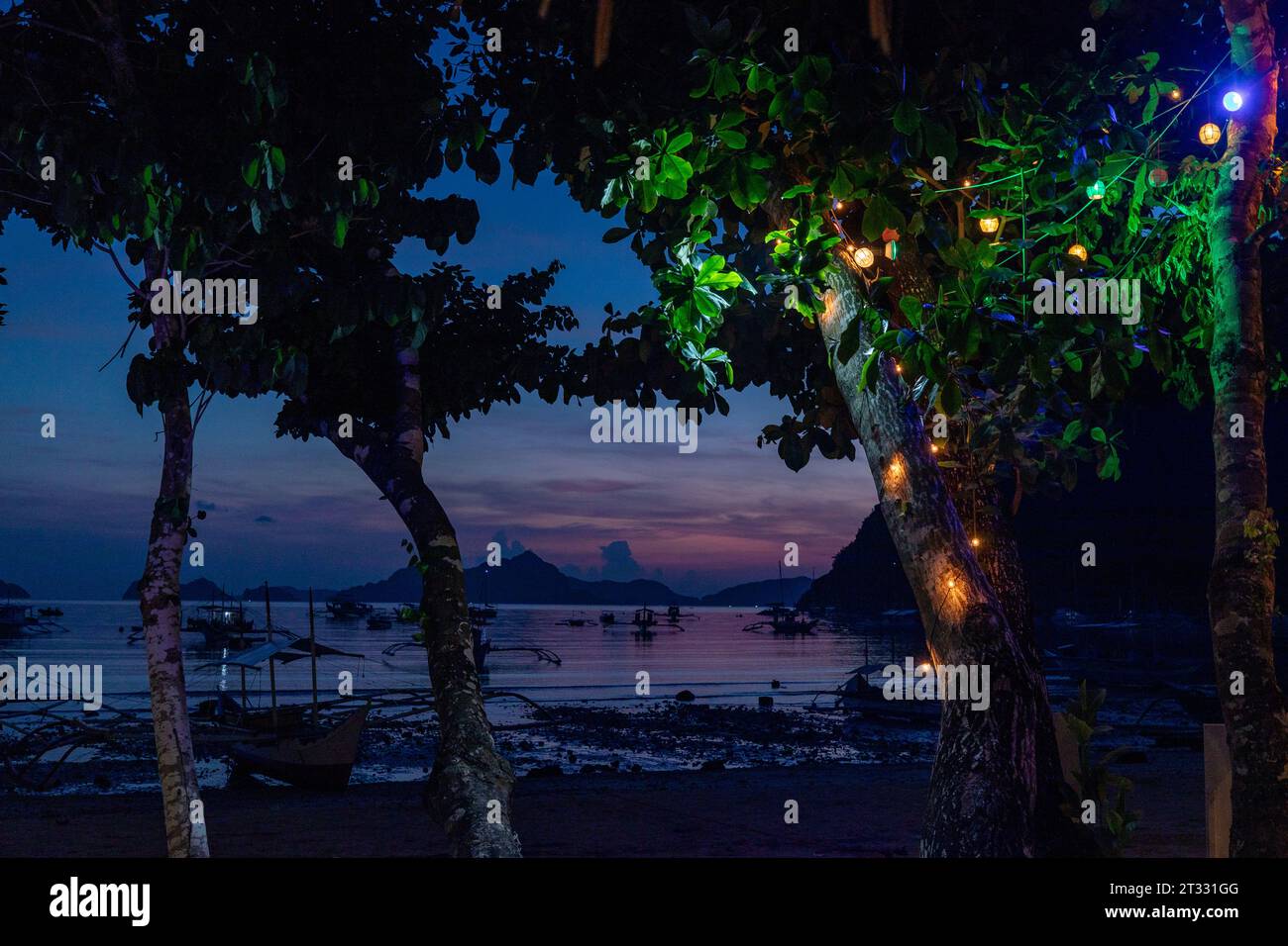 Tradizionali battelli filippini banca con balenieri ancorati al largo di notte in un paradiso tropicale Foto Stock
