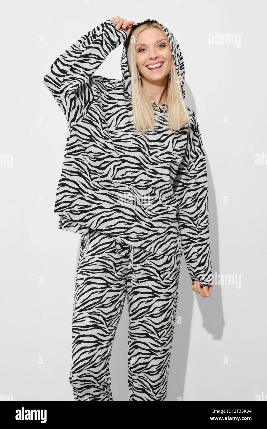 Felice donna sorridente in abito in pile zebra con cappuccio Foto Stock