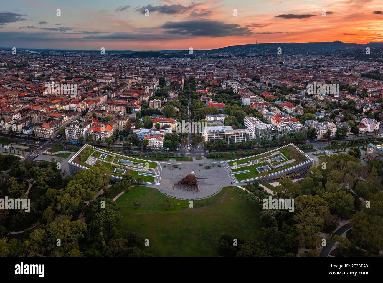 Budapest, Ungheria - Vista panoramica aerea del Museo di Etnografia nel Parco della città con lo skyline di Budapest sullo sfondo e la colorata colomba al tramonto Foto Stock