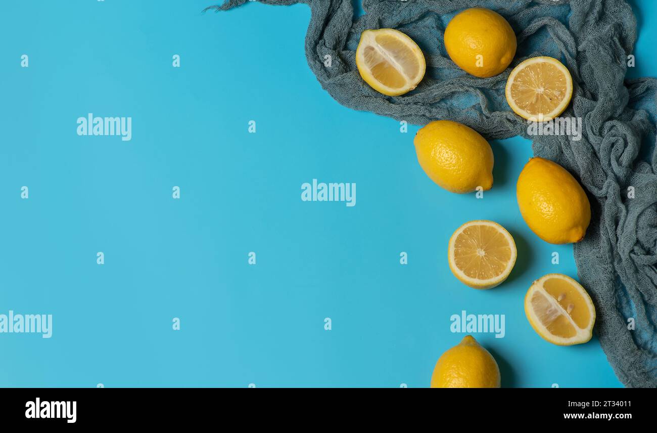 Limoni freschi e biologici su sfondo blu pastello Foto Stock