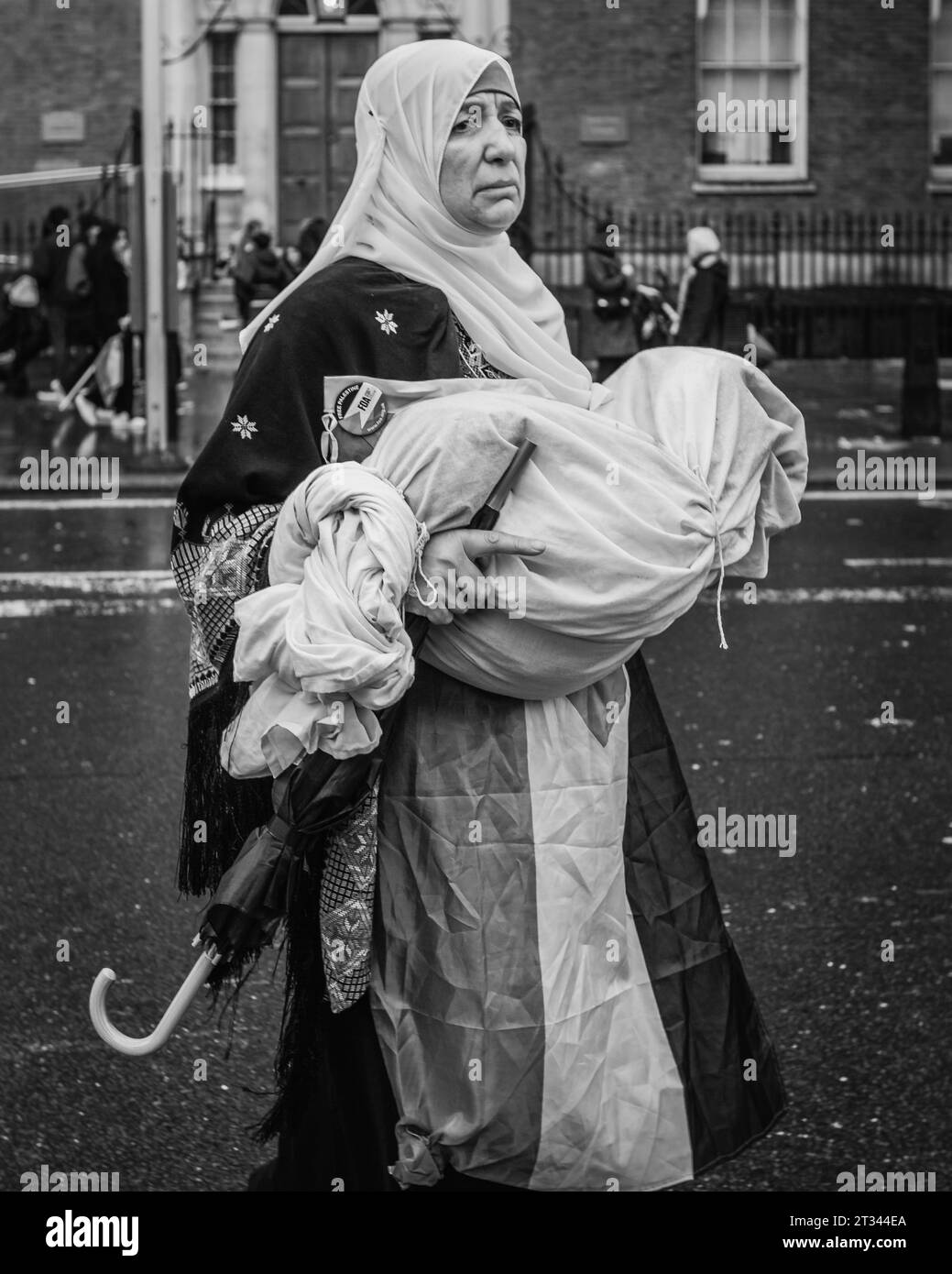Una madre palestinese con il suo bambino finto morto al raduno pro-palestinese di Londra. Foto Stock