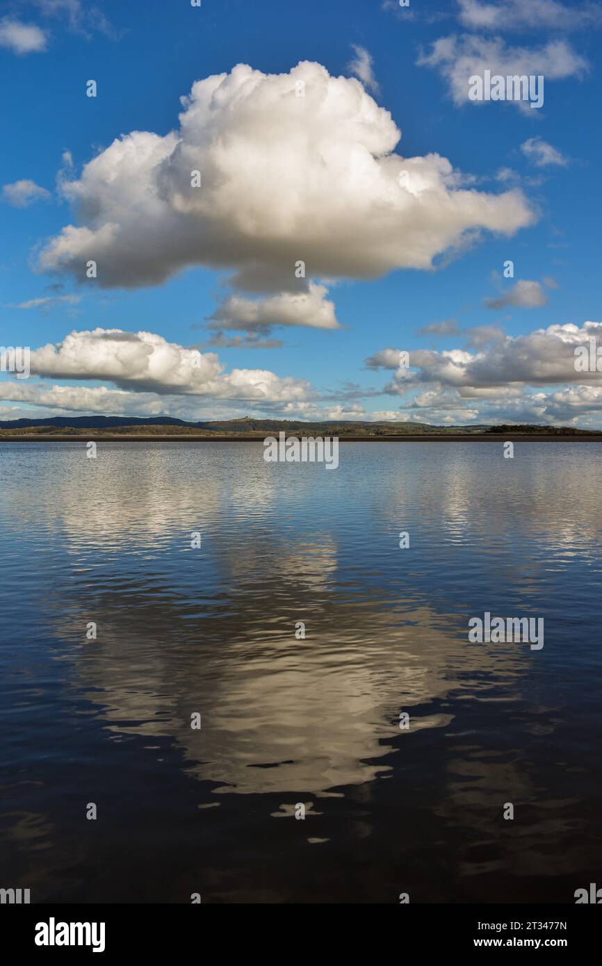 Nuvole e un cielo blu che si riflettono sulla superficie dell'acqua. Foto Stock