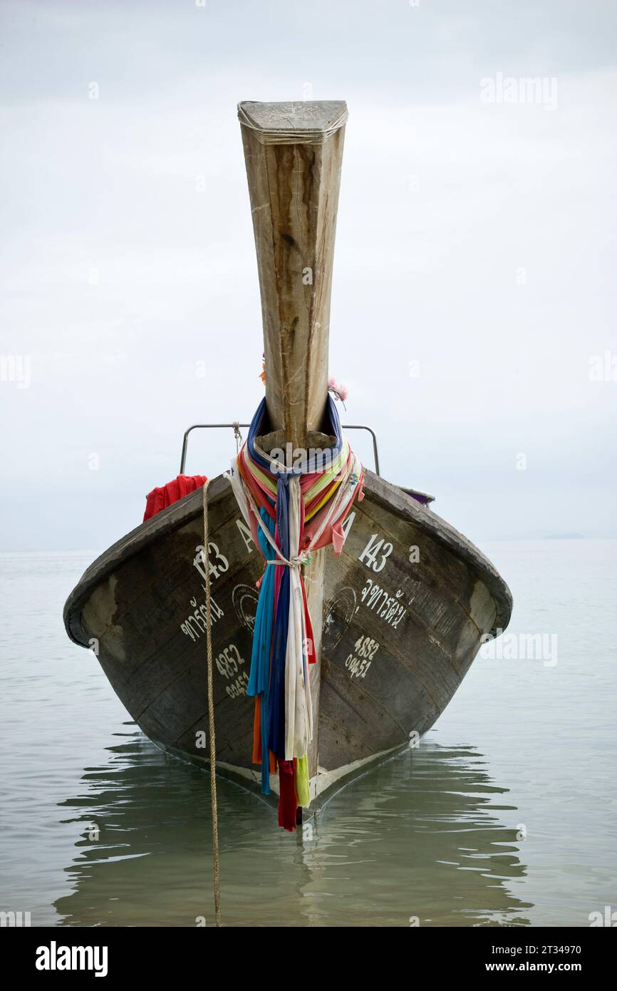 Una barca di legno ancorata al largo della costa Foto Stock