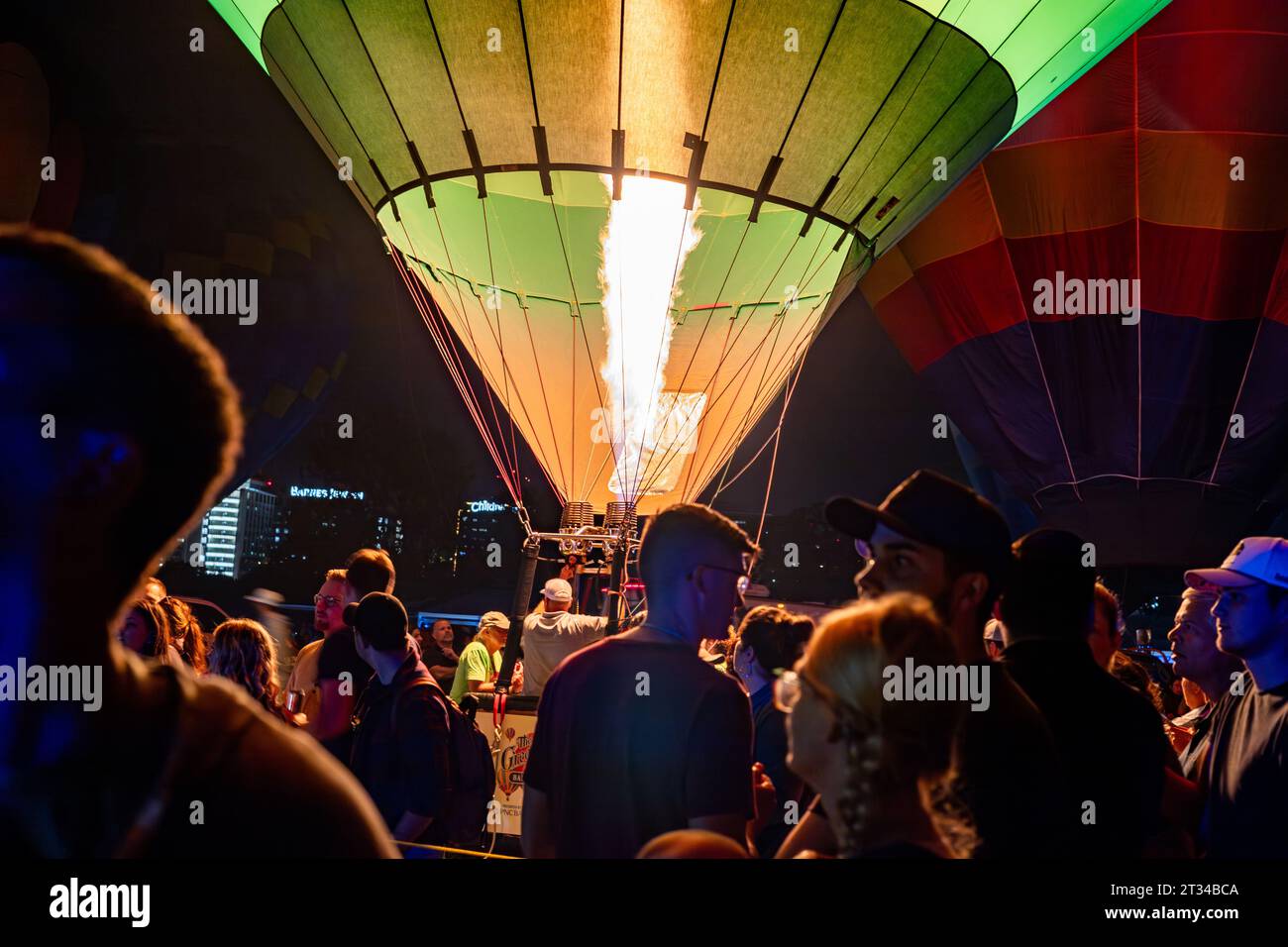 La mongolfiera si illumina mentre le persone si radunano intorno Foto Stock