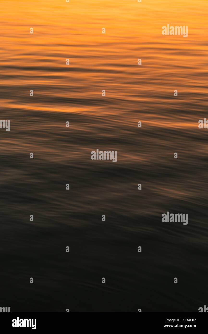 Lago calmo con luci e colori al tramonto Foto Stock