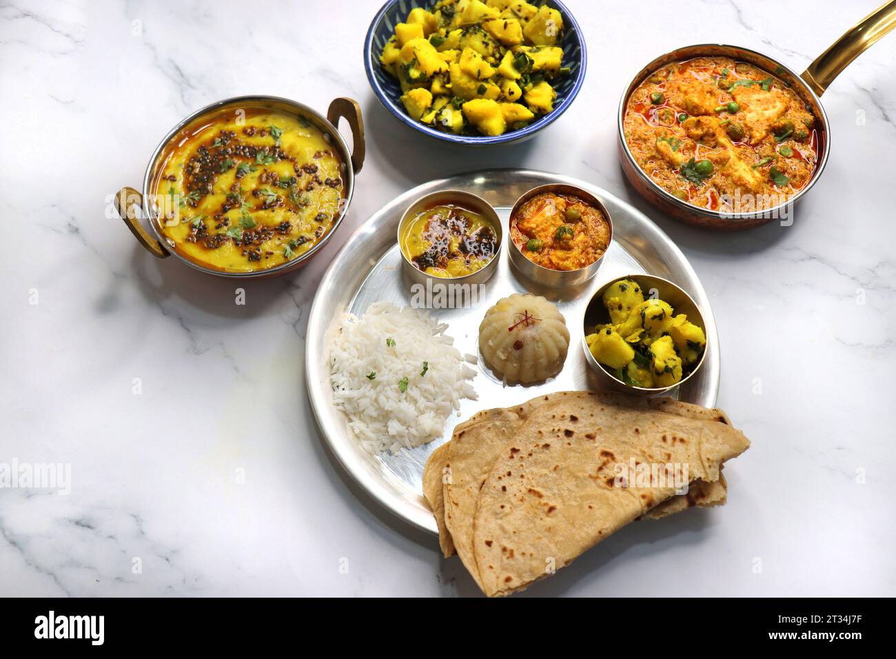 Il Thali vegetariano indiano o piatto comprende Aloo ki sabji, dal Rice, Roti bhaji, Matar Paneer, Sheera o suji ka halwa, chapati. Cibo indiano, sheera. Foto Stock