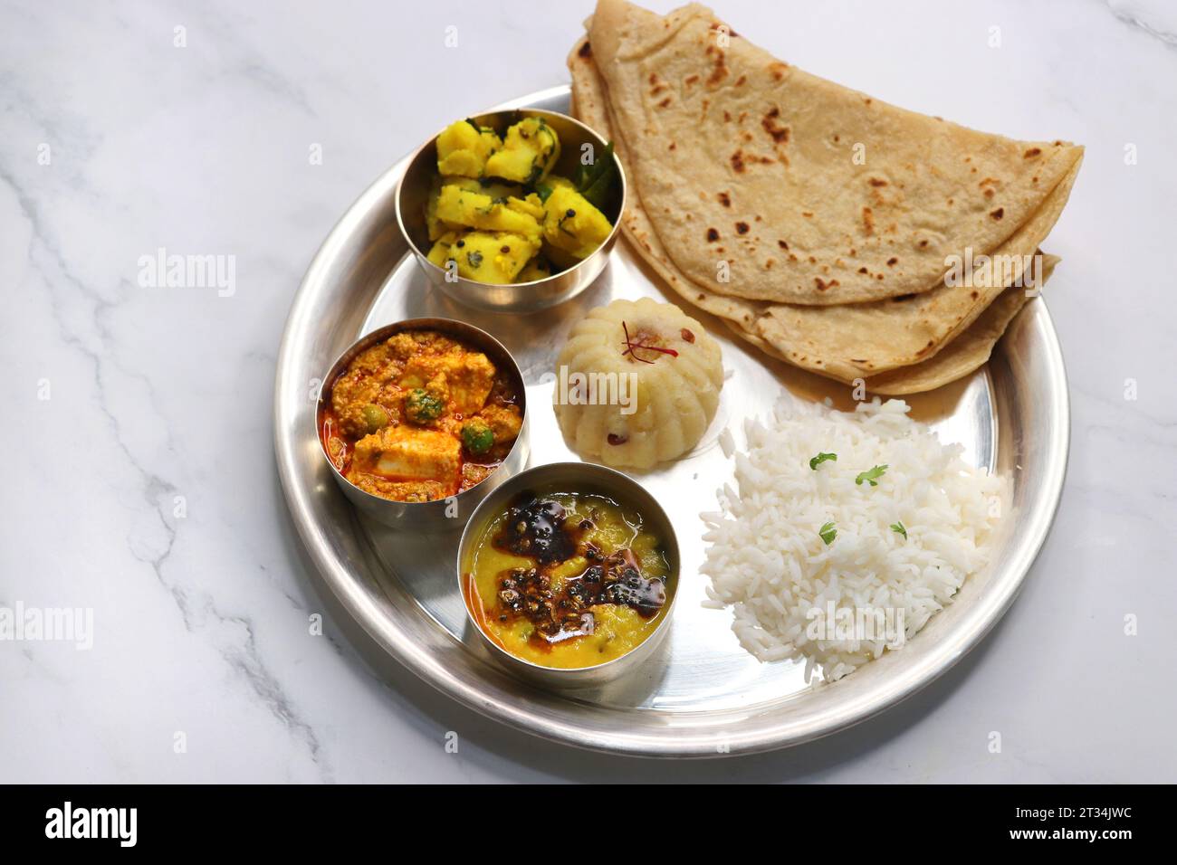 Il Thali vegetariano indiano o piatto comprende Aloo ki sabji, dal Rice, Roti bhaji, Matar Paneer, Sheera o suji ka halwa, chapati. Cibo indiano, sheera. Foto Stock