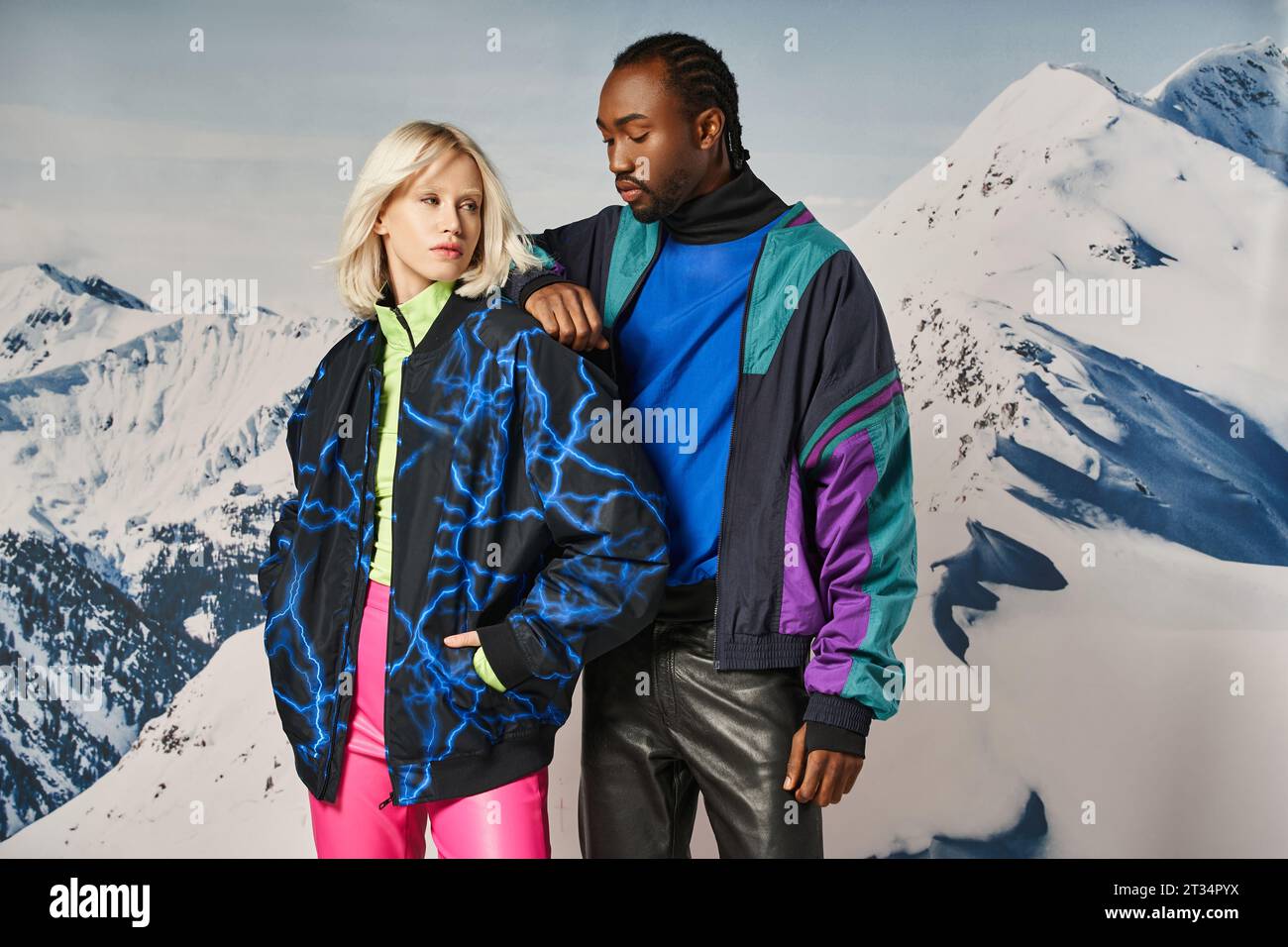 attraente coppia multirazziale in abiti caldi e vivaci con la mano sulle spalle, concetto invernale Foto Stock