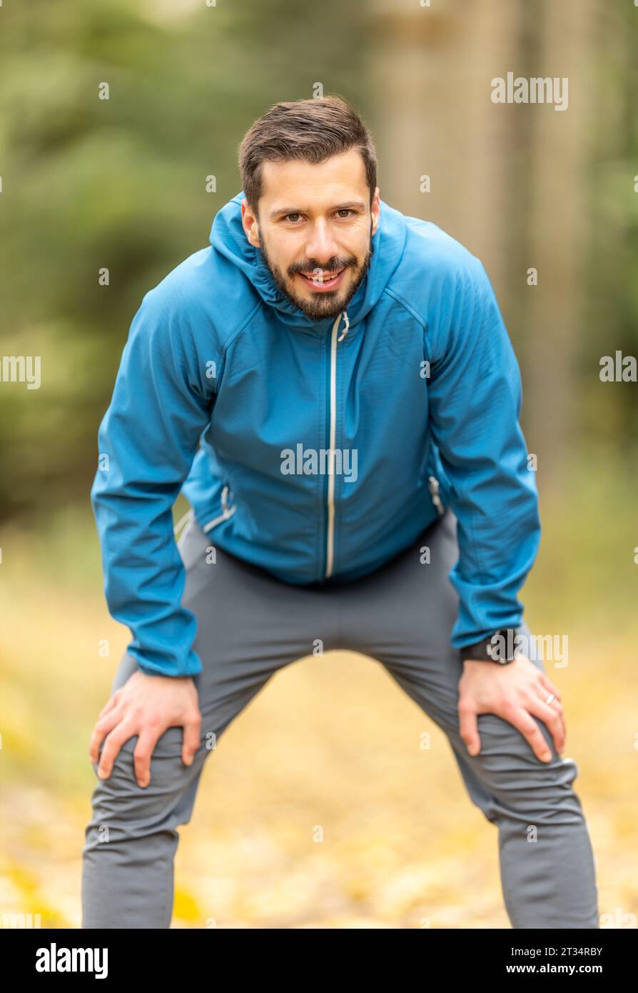 Ritratto di un giovane sportivo di bell'aspetto che riposa e guarda la fotocamera. Foto Stock