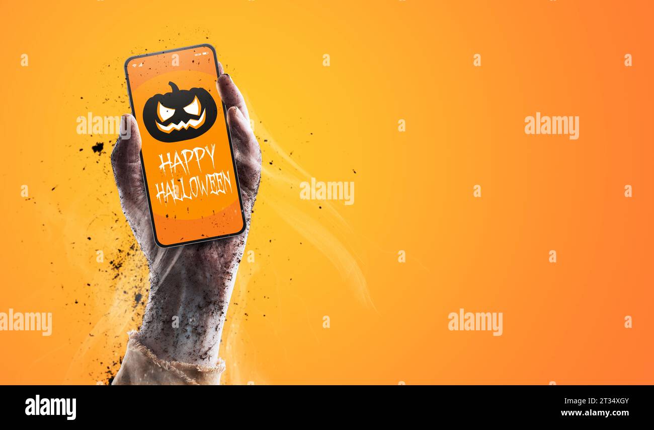 Zombie in possesso di uno smartphone con il concetto di auguri, festività e festeggiamenti di Halloween Foto Stock