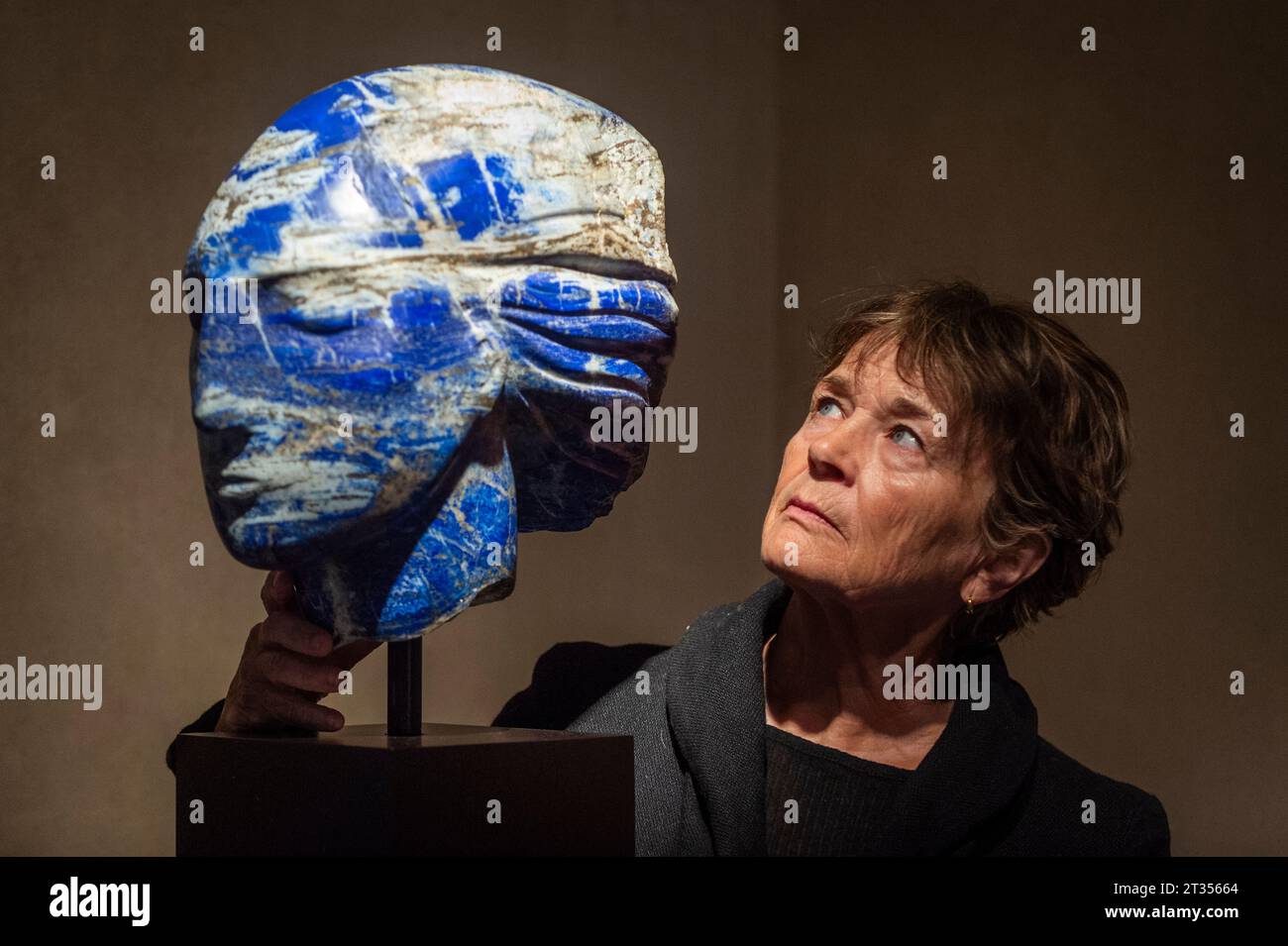 Londra, Regno Unito. 23 ottobre 2023. l’incisore britannica Emily Young con il suo lavoro “Daughter of the Sky II”, Lapis lazuli afghano di 2,5 miliardi di anni, in anteprima della sua nuova mostra intitolata “Pareidolia in pietra”. Le sue opere, in una varietà di materiali in pietra ritrovata, sono in mostra alla galleria Richard Green in Bond Street, dal 25 ottobre al 10 novembre 2023. Crediti: Stephen Chung / Alamy Live News Foto Stock