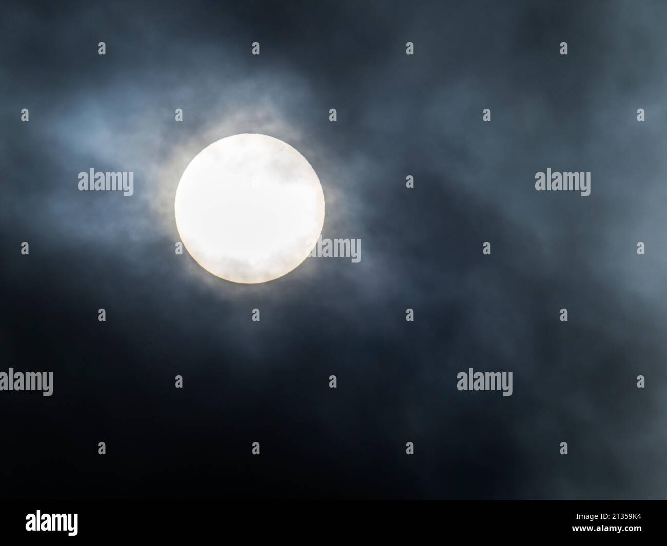 Nuvole che si addormentano davanti al sole con punti di sole visibili su Ambleside, Lake District, Regno Unito Foto Stock