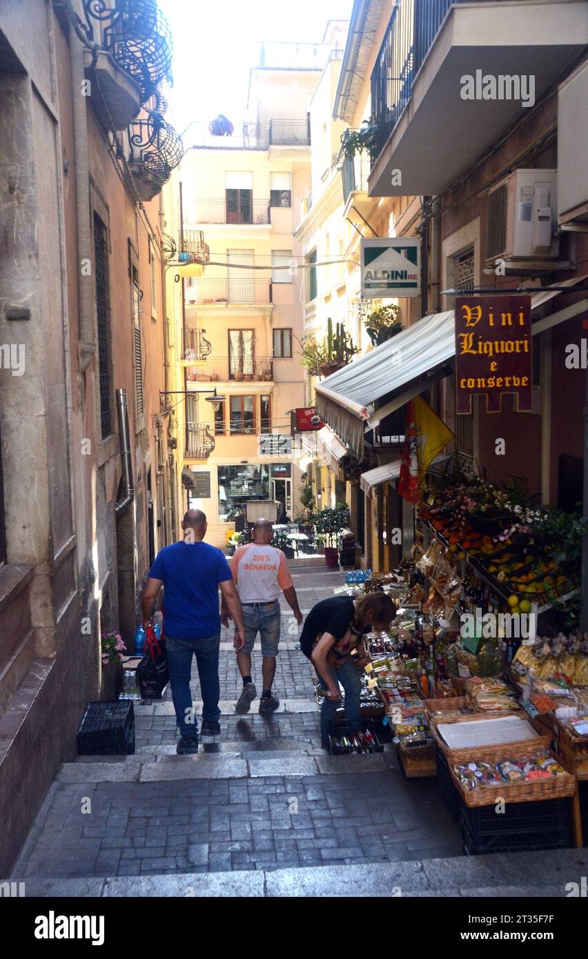 Persone/turisti passeggiando ed esplorando le antiche stradine del villaggio di Taormina in Sicilia, Italia, UE. Foto Stock
