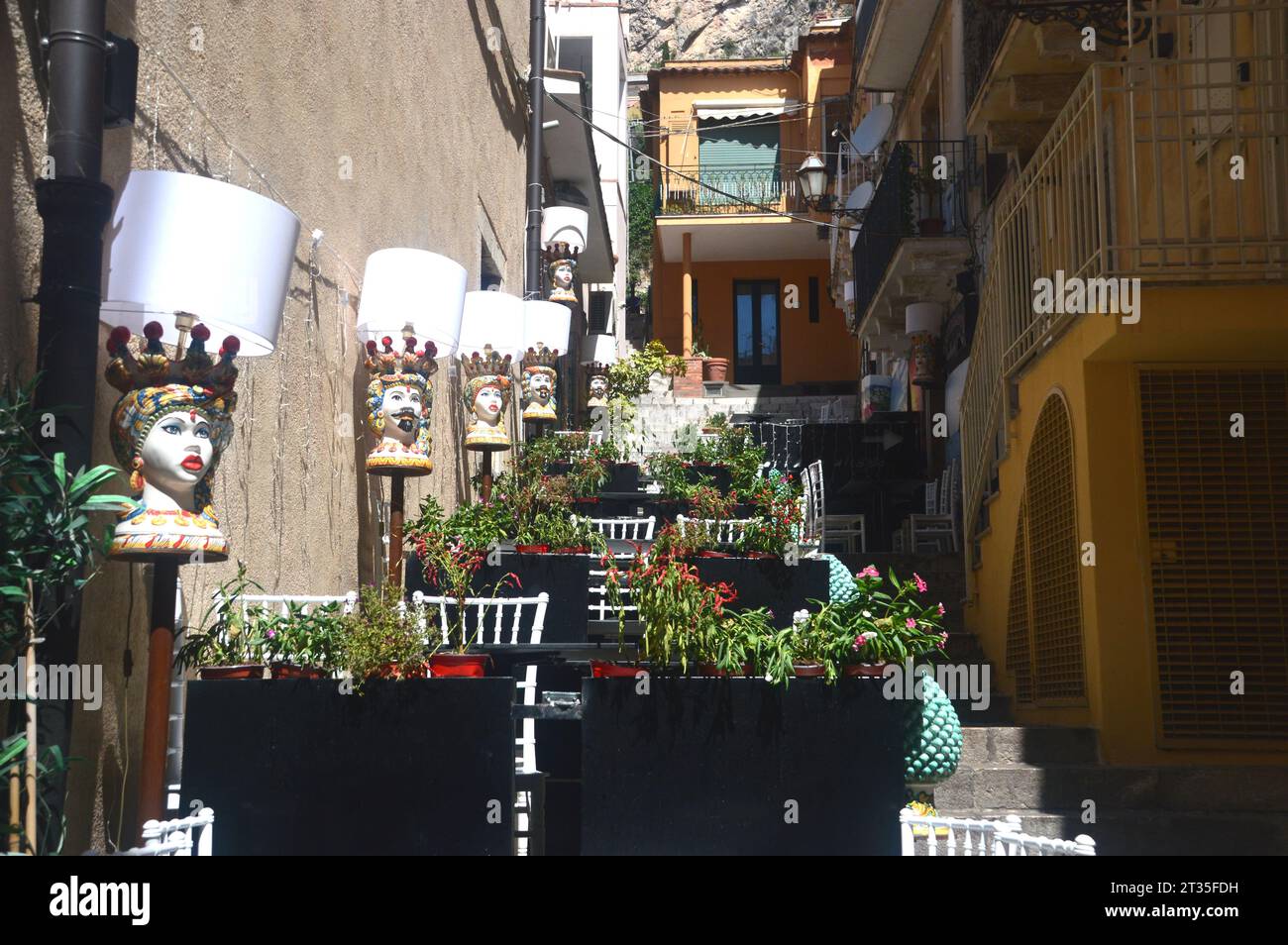 Testa di Moro (testa di Moro) dai colori vivaci teste moresche dipinte in ceramica su una parete all'esterno di un tradizionale ristorante siciliano a Taormina, in Sicilia. Foto Stock