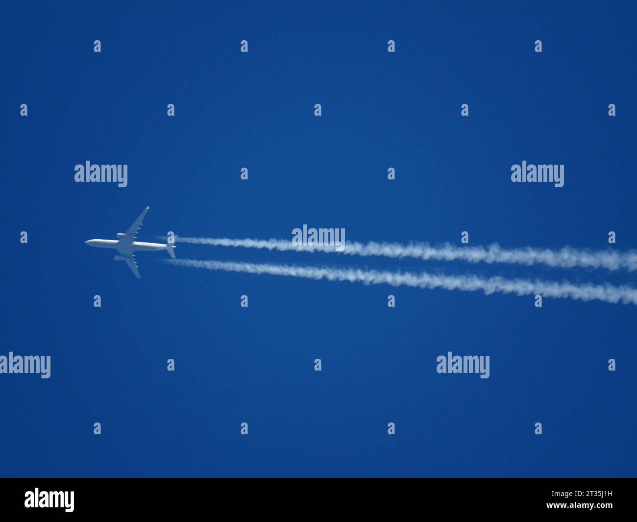 Primo piano di un aereo di linea che vola ad alta quota con i contrafforti in un cielo azzurro Foto Stock