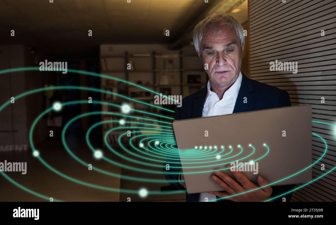 Immagine digitale composita di un uomo d'affari senior che utilizza un notebook con luci a vortice Foto Stock