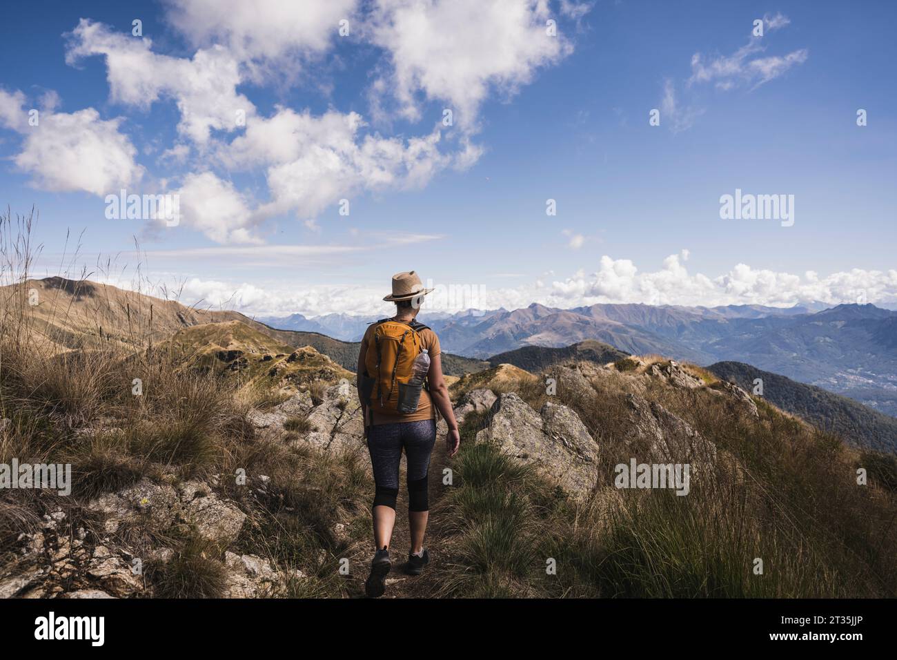 Escursionista con zaino che cammina tra le montagne rocciose Foto Stock