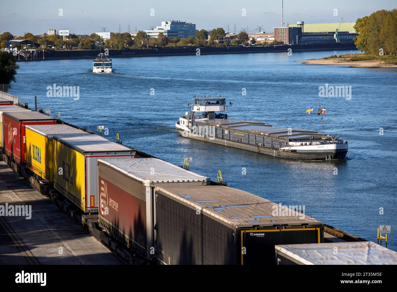 Nave da carico che entra nel porto del Reno Niehl, rimorchi per camion in piedi presso il terminal Westkai di Colonia, Germania. Frachtschiff faehrt in den Niehler Hafen, Foto Stock