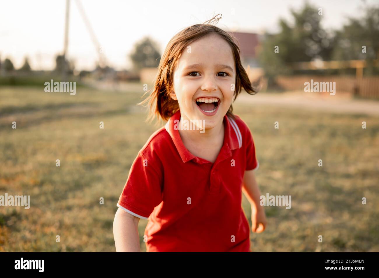 Un ragazzo allegro che si diverte a campo nelle giornate di sole Foto Stock