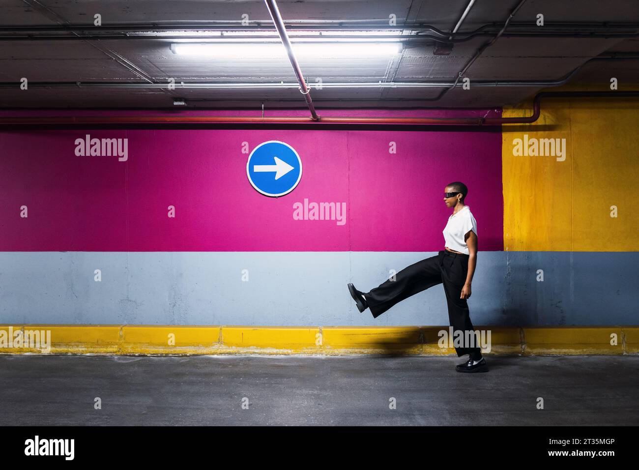 Giovane donna d'affari che cammina davanti al muro Foto Stock