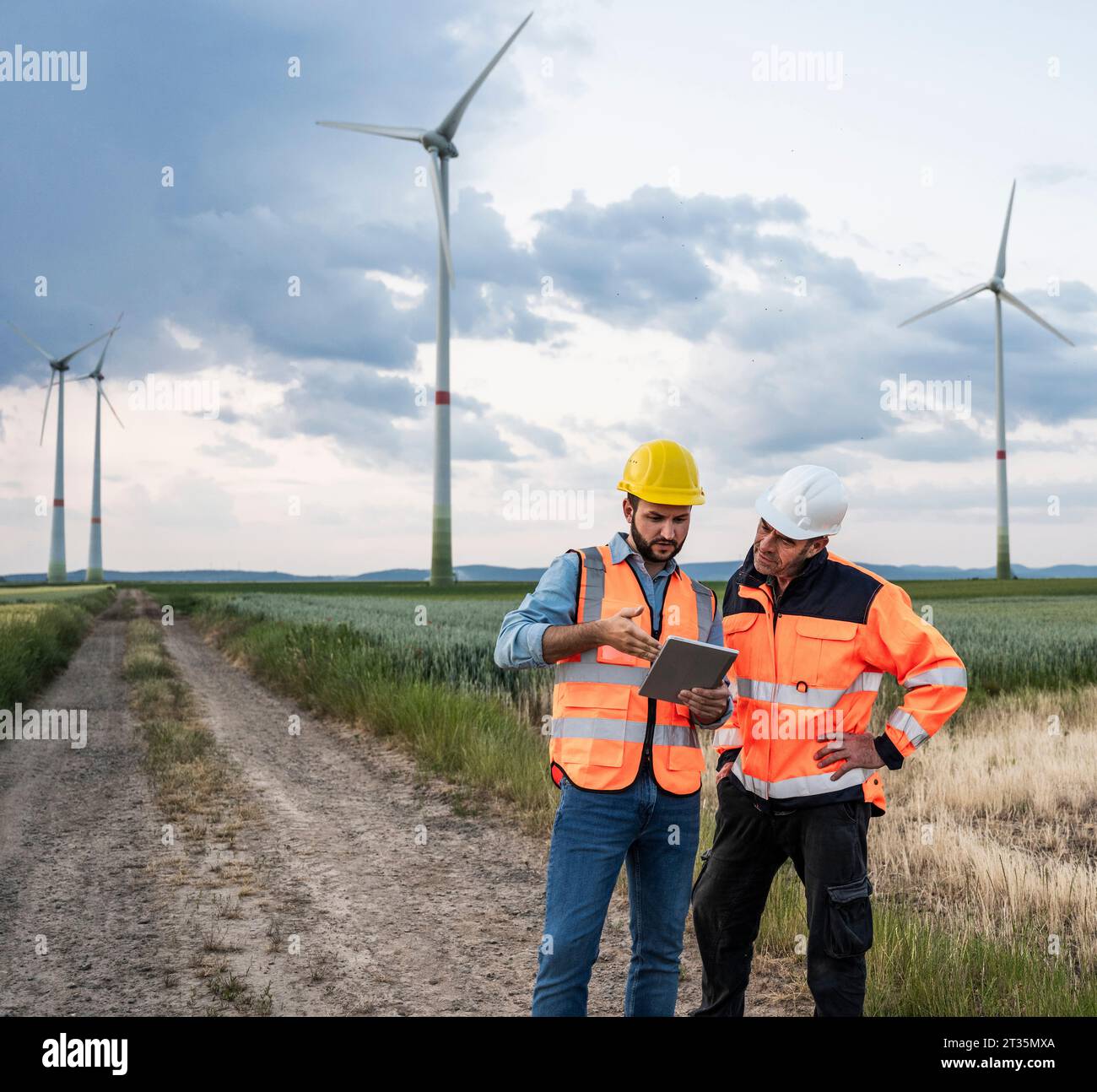 Ingegneri che lavorano insieme con un tablet presso un parco eolico Foto Stock