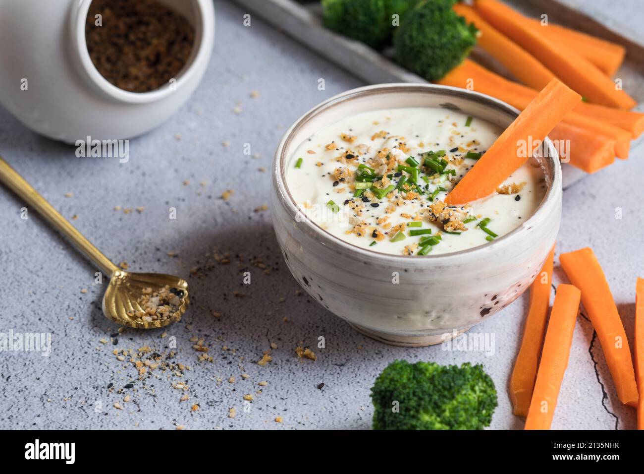 Ciotola di salsa al miele di feta, carote crude e broccoli Foto Stock