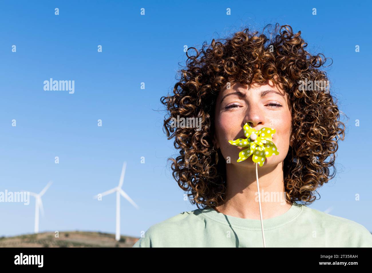 Donna che tiene il giocattolo della ruota sulla bocca Foto Stock