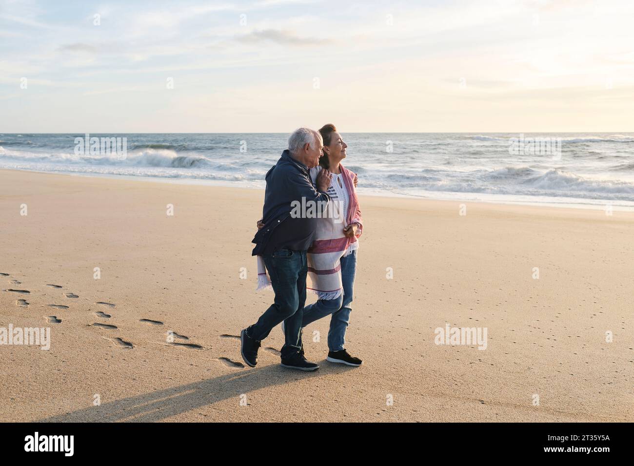Adorabile coppia anziana che cammina sulla sabbia in spiaggia Foto Stock