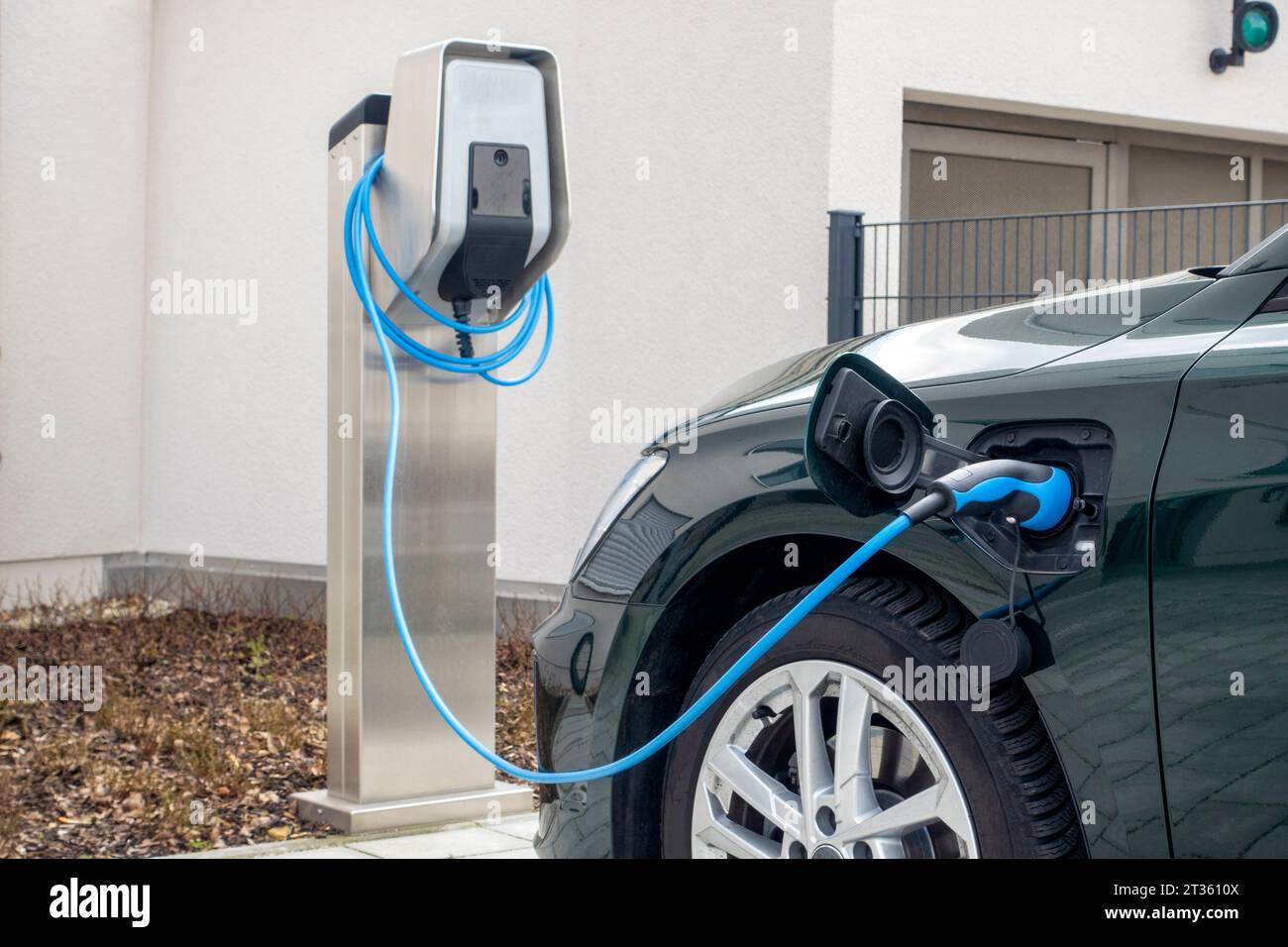 Ricarica dell'auto presso la stazione di ricarica per veicoli elettrici Foto Stock