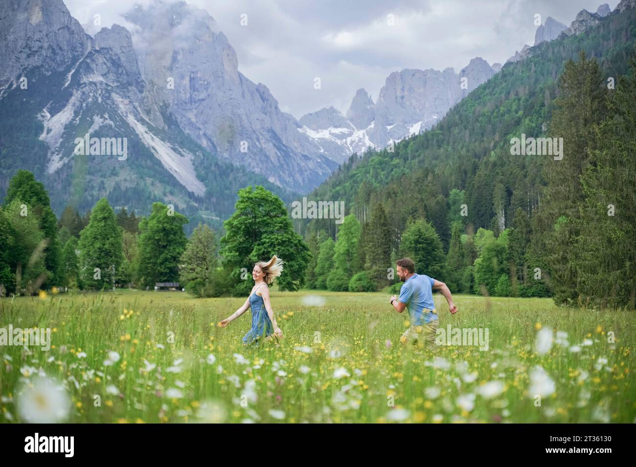 Uomo e donna che corrono di fronte alle montagne Foto Stock