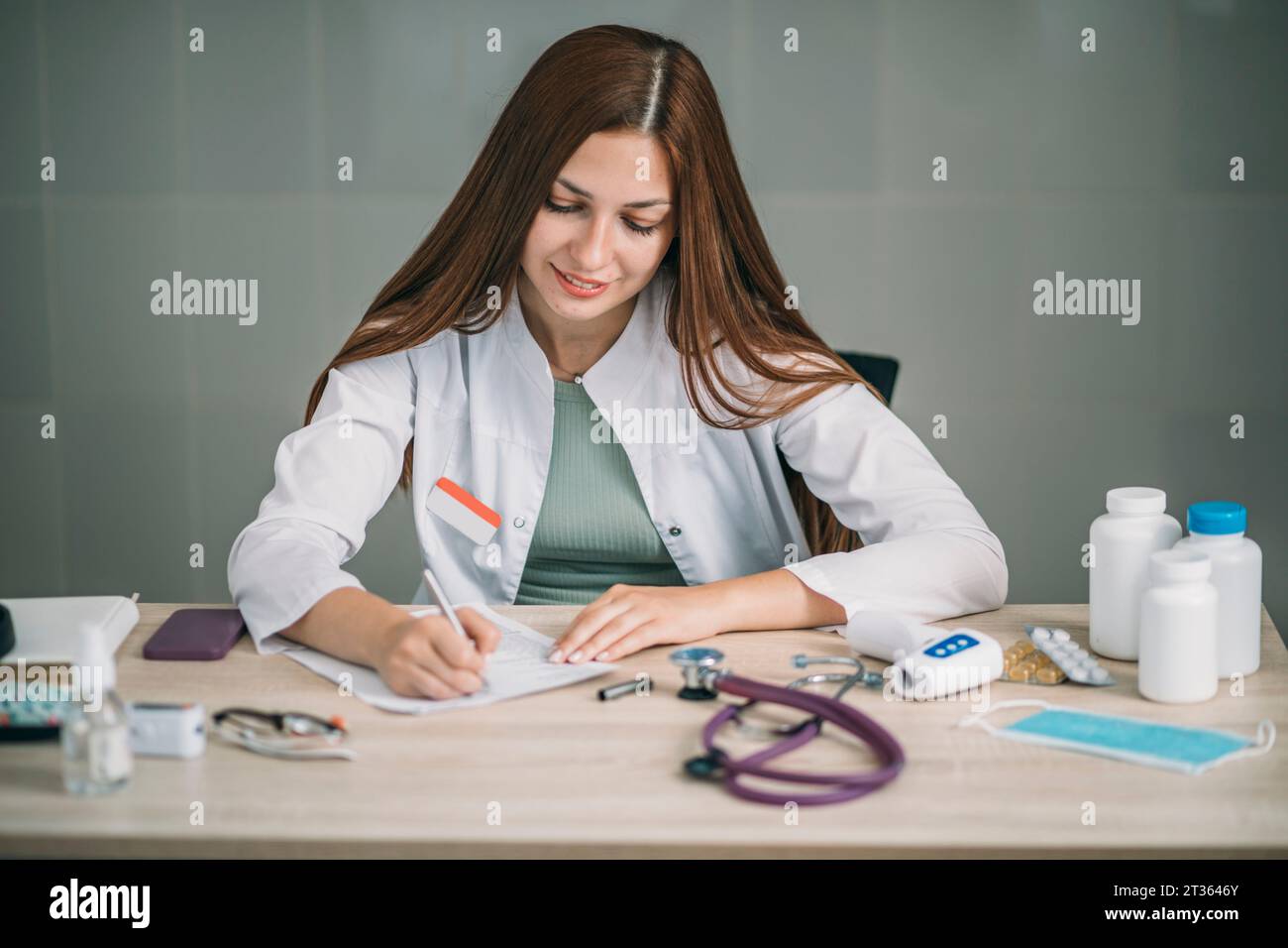 Medico donna che scrive prescrizione presso la clinica medica Foto Stock