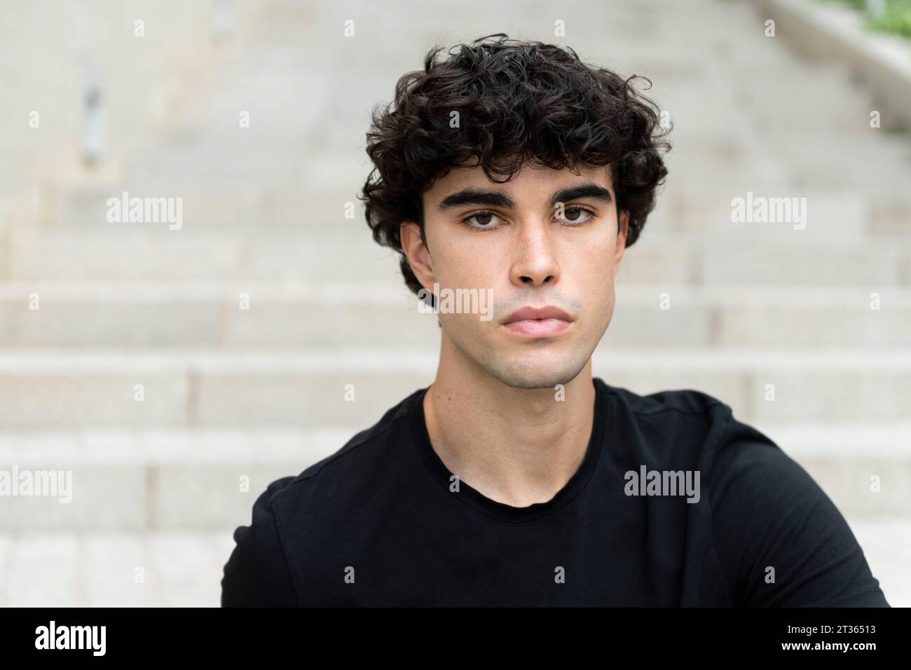 Giovane uomo serio con i capelli neri Foto Stock