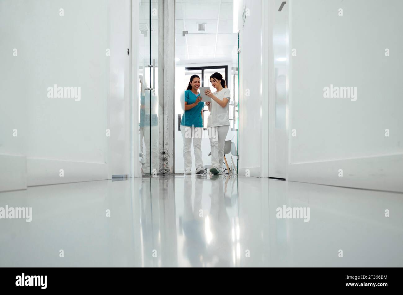 Dentista che discute con un collega su un tablet PC in clinica Foto Stock