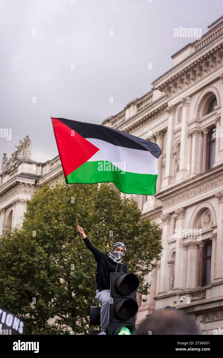 Protesta in cima a un semaforo che sgancia una bandiera palestinese nella Whitehall, protesta pro-palestinese nel centro di Londra il 21/10/2023, Inghilterra, Regno Unito Foto Stock