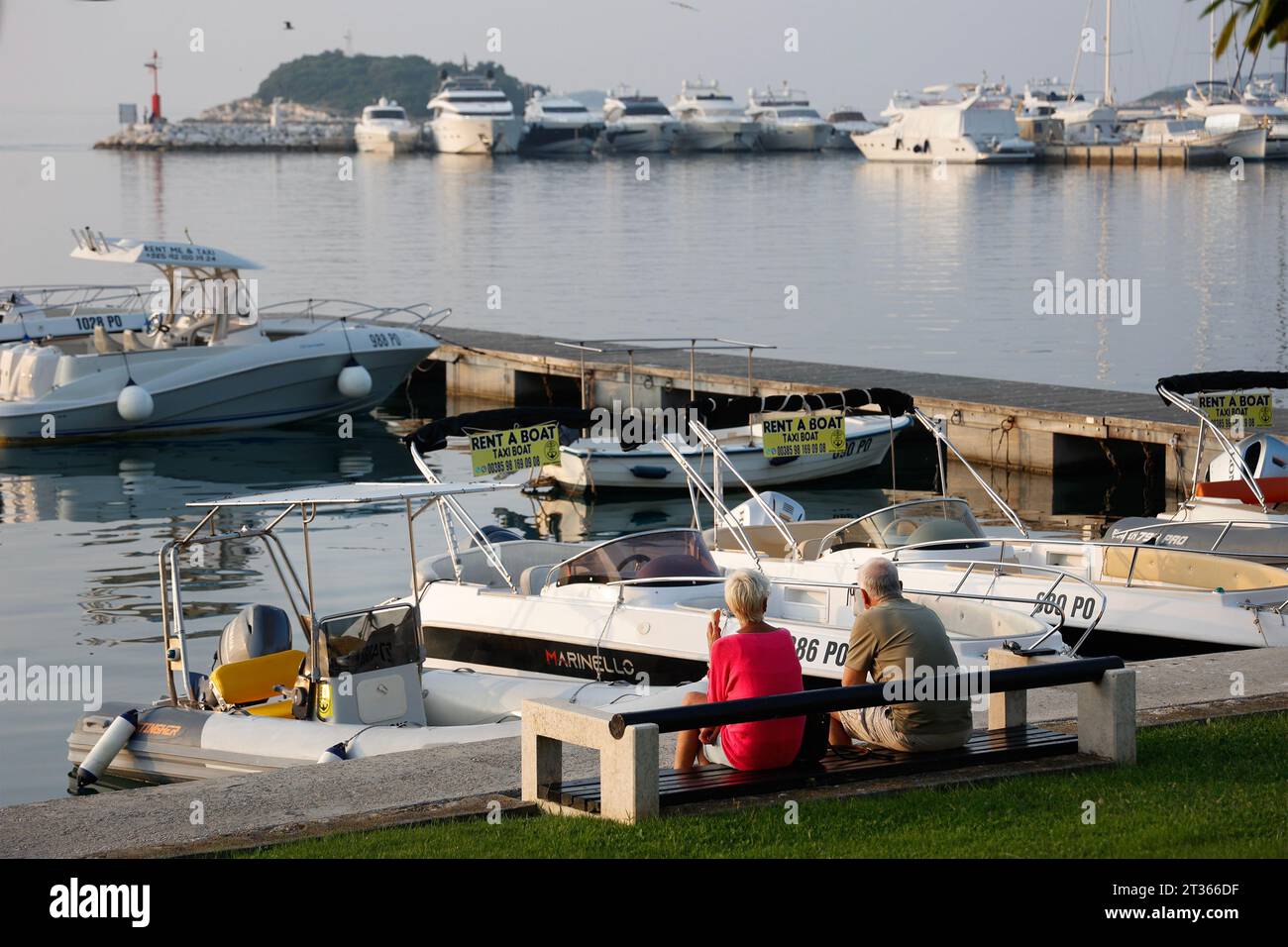 Coppia anziana seduta su una panchina vicino al porto degli yacht di Vrsar, Istria, Croazia Foto Stock