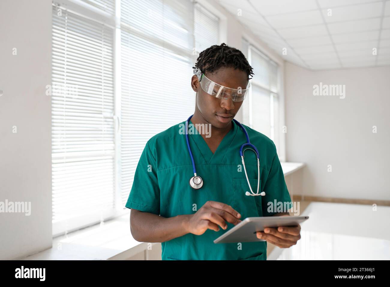 Studente medico che indossa occhiali intelligenti e utilizza tablet PC in ospedale Foto Stock