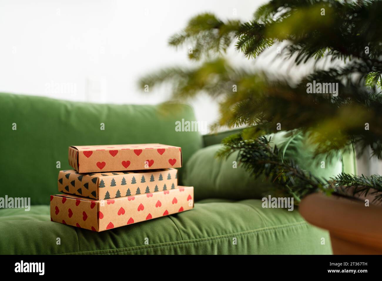 Regali di Natale sul divano verde a casa Foto Stock