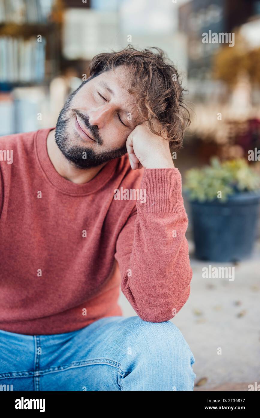 Uomo stanco con gli occhi chiusi appoggiati al gomito Foto Stock