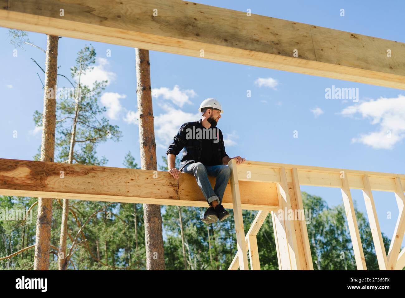 Ingegnere seduto su una struttura in legno in cantiere Foto Stock