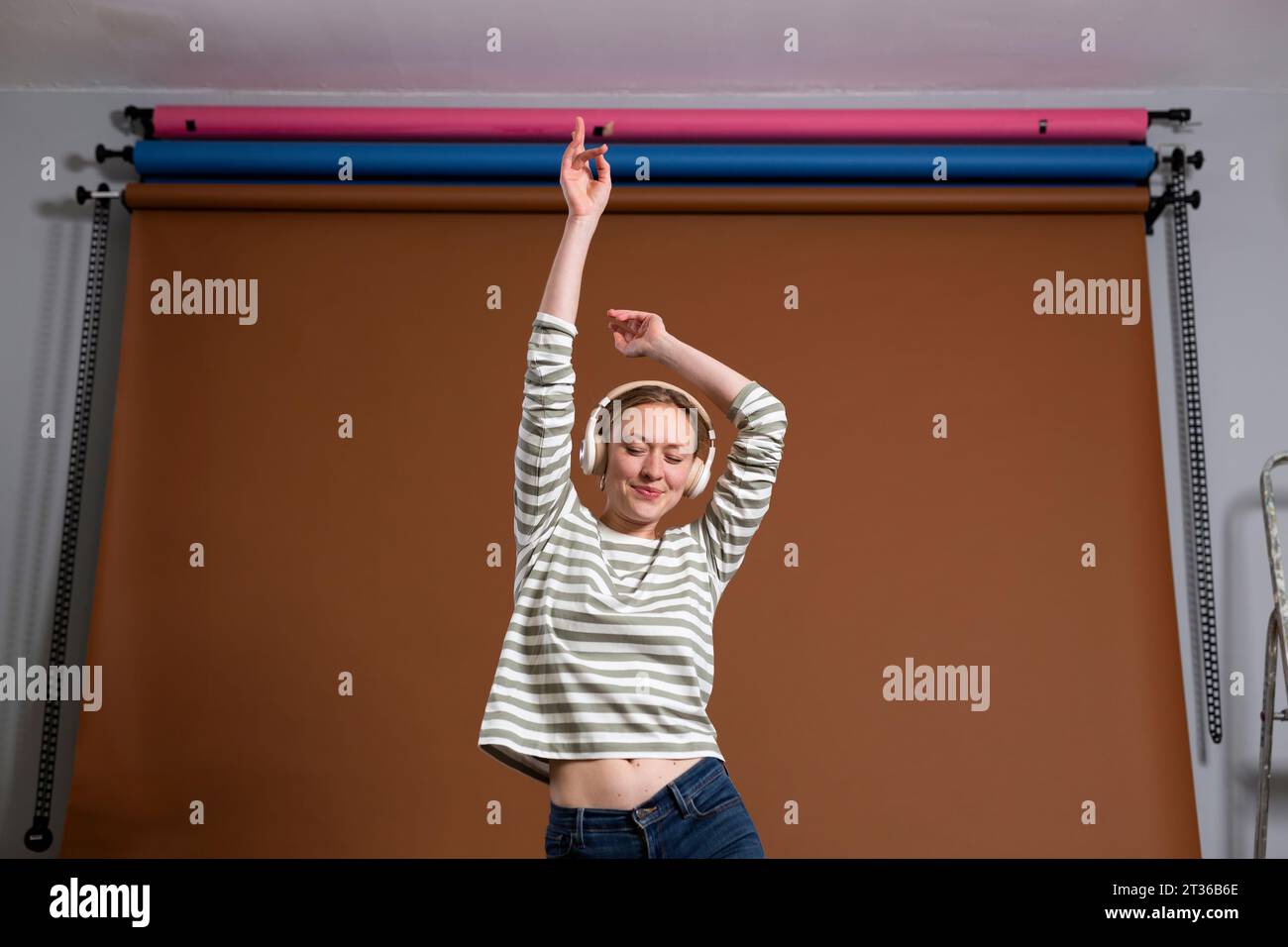 Donna che ama ballare e ascoltare musica con le cuffie in studio Foto Stock