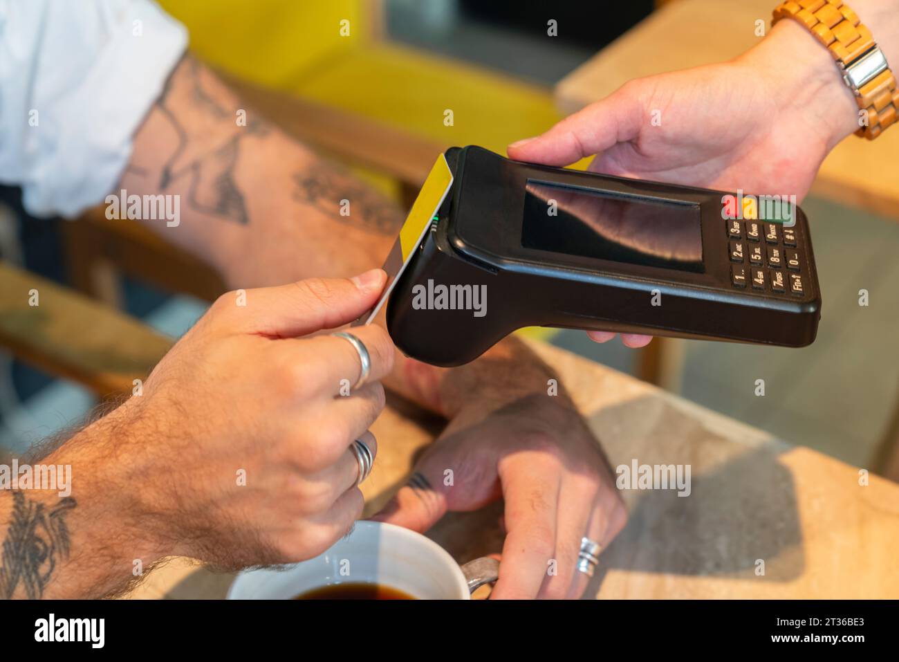 Un uomo che paga alla spina per pagare alla caffetteria Foto Stock