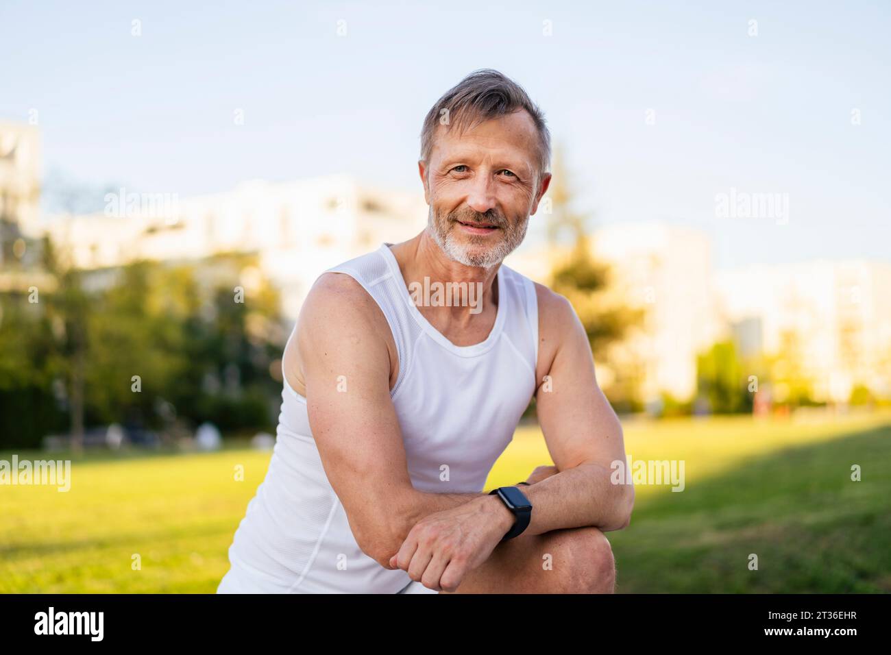 Atleta maturo sorridente in piedi nel parco Foto Stock