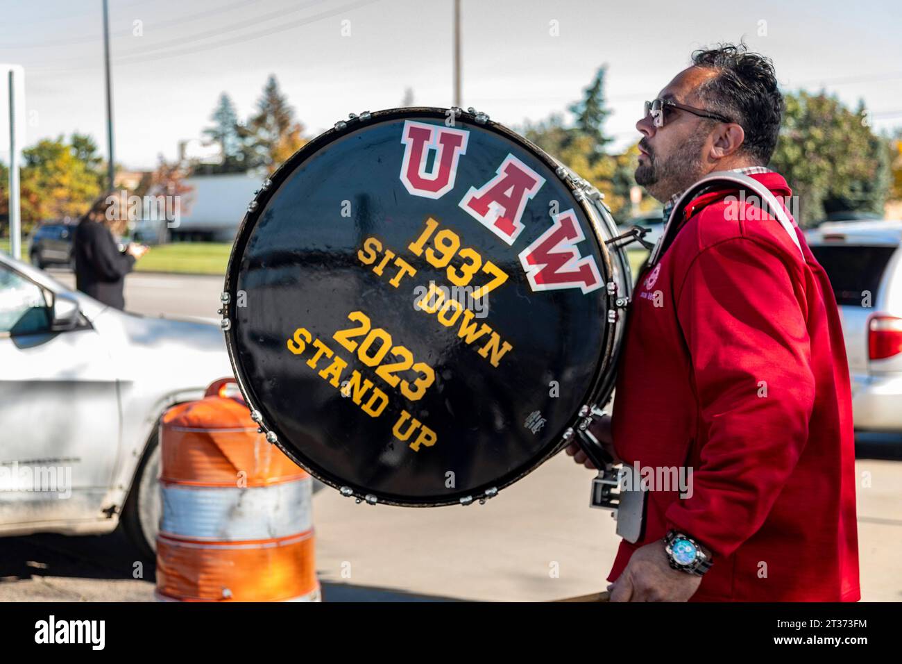 Sterling Heights, Michigan, USA. 23 ottobre 2023. I membri della United Auto Workers ampliarono il loro sciopero, uscendo allo stabilimento di Sterling Heights di Stellantis (SHAP). Un membro dell'UAW ha un tamburo che confronta lo sciopero Sit Down del 1937 dell'unione con quello del 2023. Crediti: Jim West/Alamy Live News Foto Stock