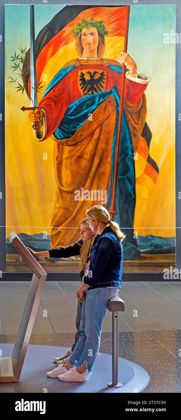 Due donne su uno schermo di fronte al dipinto della Germania di Philipp Veit, Haus der Geschichte, Bonn, Renania settentrionale-Vestfalia, Germania Foto Stock