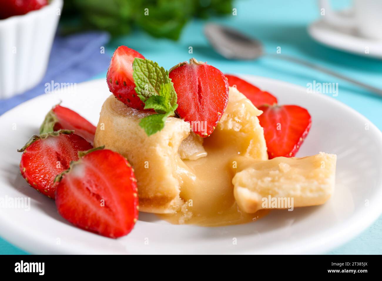 Saporita fondente alla vaniglia con cioccolato bianco e fragole sul tavolo, primo piano Foto Stock
