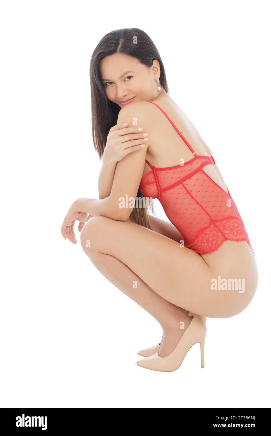 Sexy donna asiatica in posa per uno studio di figura che indossa lingerie rossa isolata su uno sfondo bianco con spazio per le copie Foto Stock