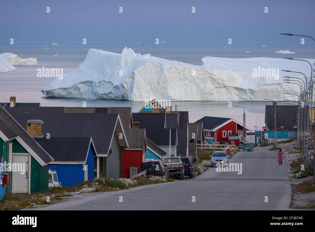 Scena di strada a Ilulissat con case colorate e iceberg Foto Stock